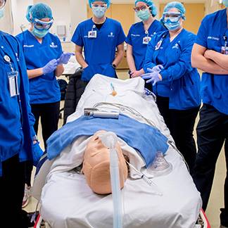 KCON Lab nursing students with a total care manikin
